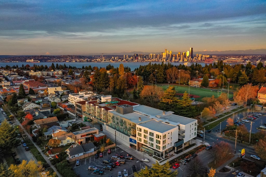 A cityscape with a large building in the foreground and a city skyline in the background.