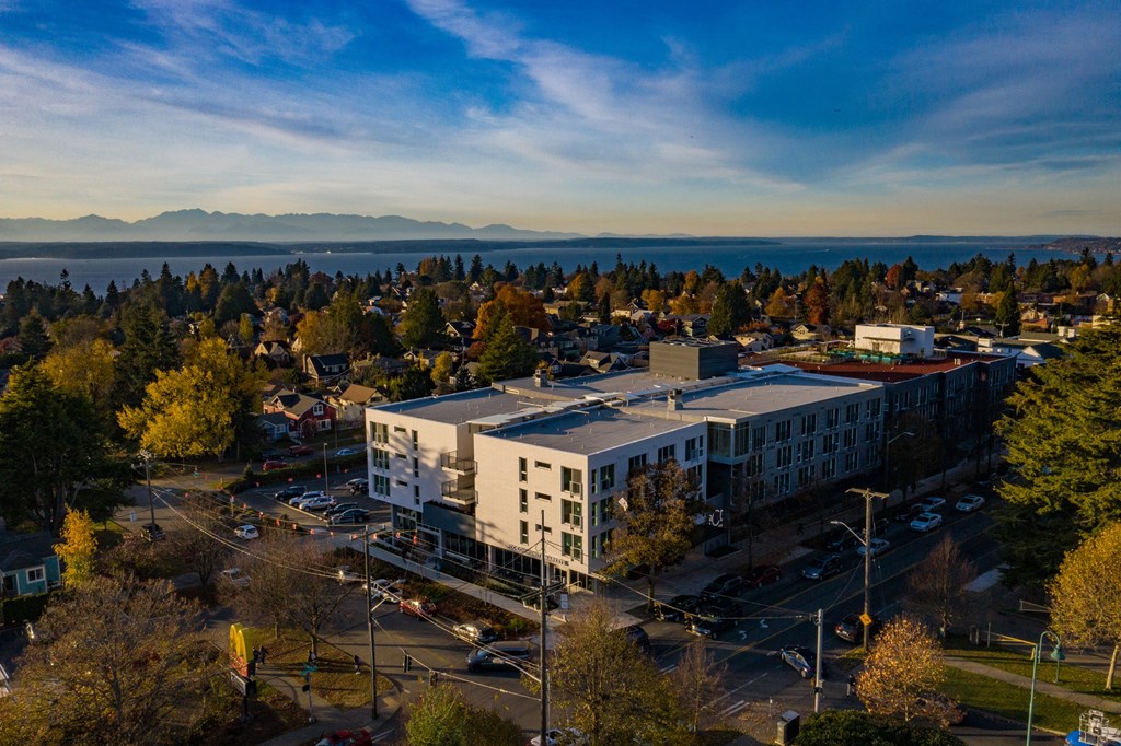 an aerial view of a building with a lake in the background