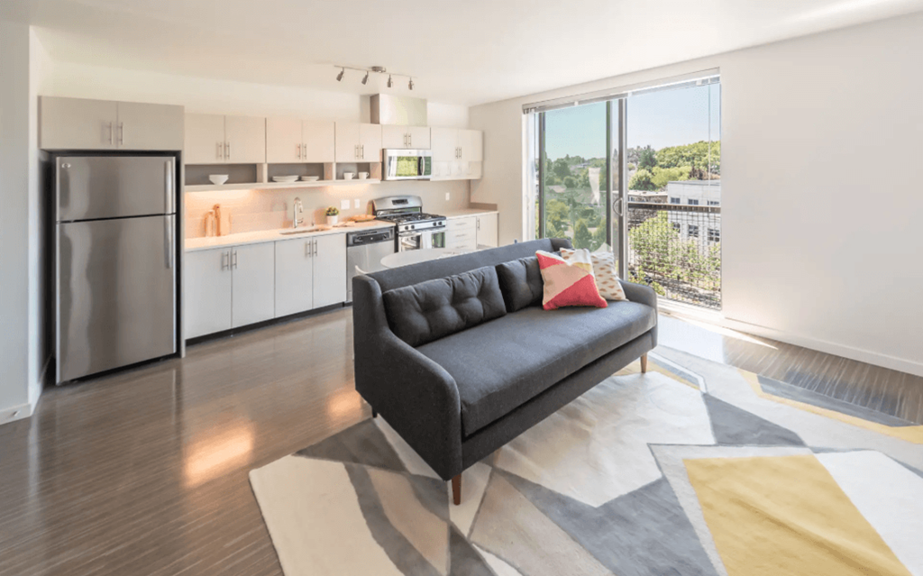 a couch in a living room with a kitchen in the background