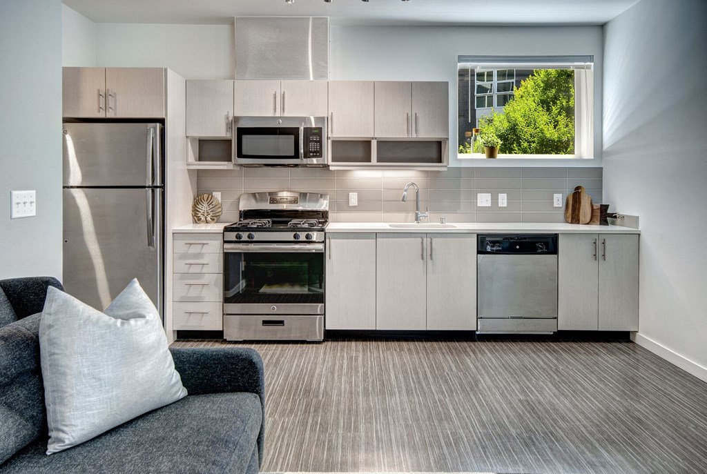a kitchen with white cabinets and stainless steel appliances