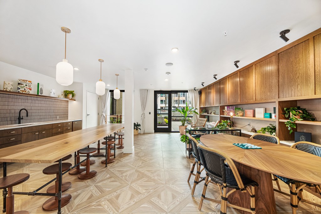 A modern kitchen with a long wooden table and chairs.