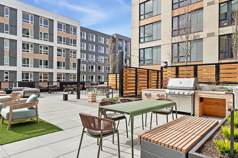 A patio with a table and chairs is surrounded by buildings.