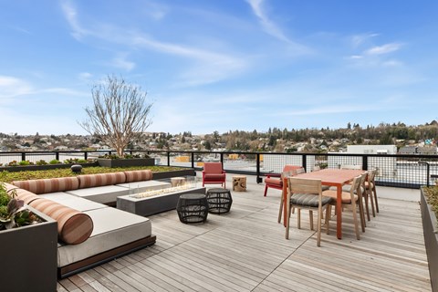 A wooden deck with a table and chairs overlooking a cityscape.