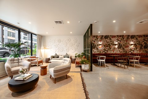 A living room with a large floral wallpaper and a variety of seating options.