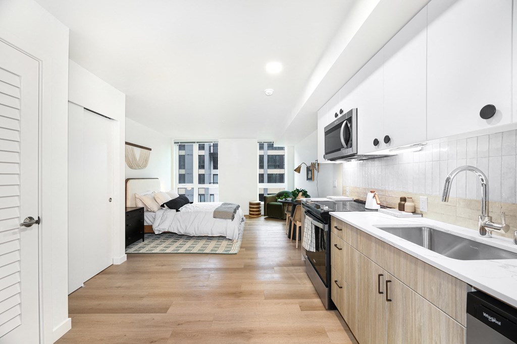 A kitchen with a white counter top and wooden cabinets.
