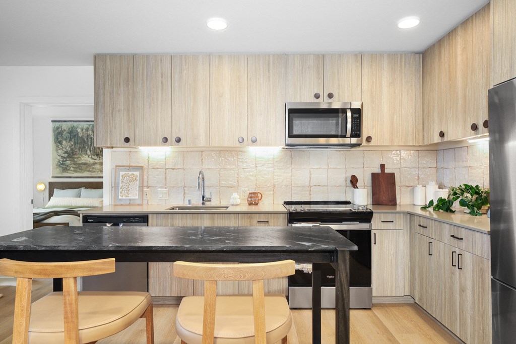 A kitchen with wooden cabinets and a black countertop.