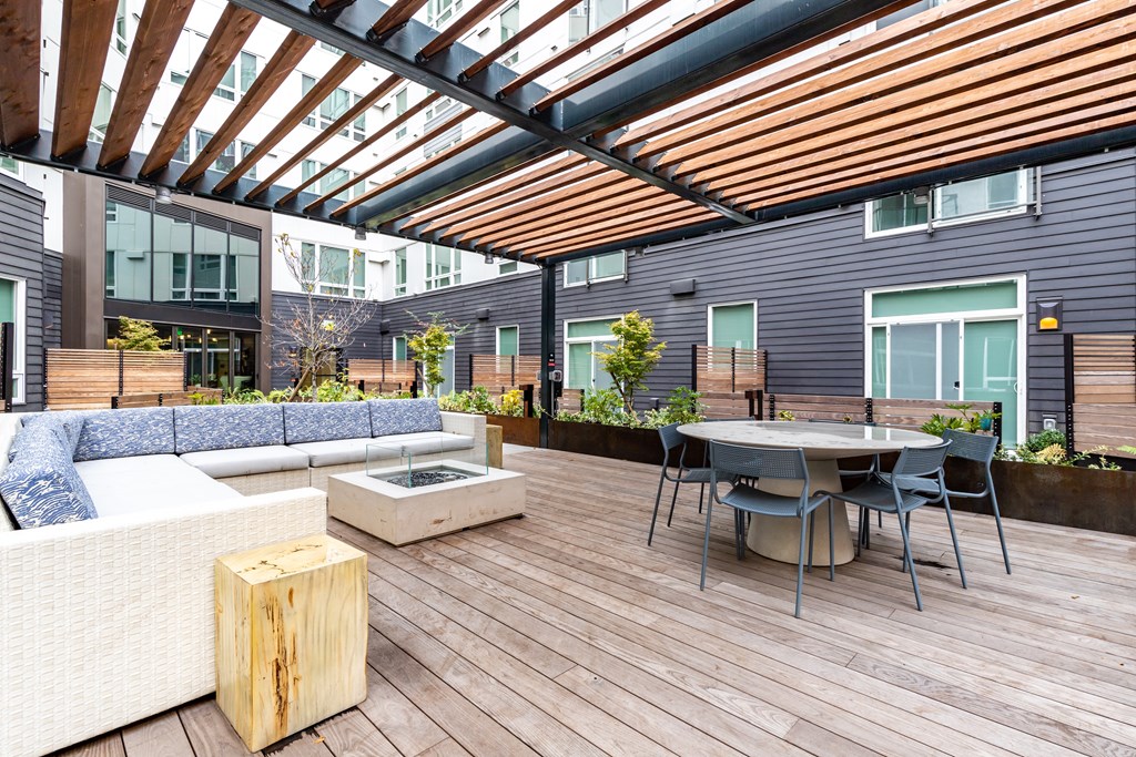a patio with a table and chairs under a roof