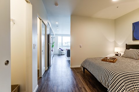 a bedroom with a bed and a hallway to a bathroom