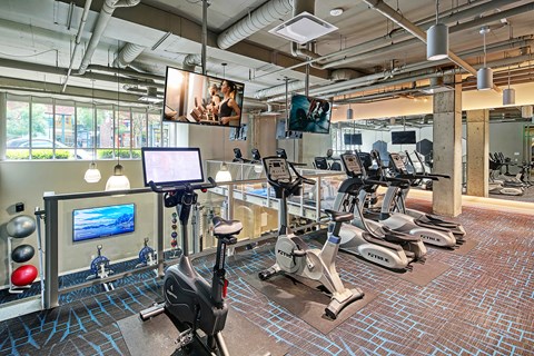 A gym with exercise bikes and a television.