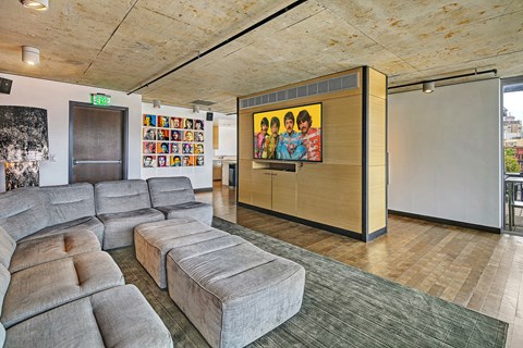 A room with a couch and a painting of a group of people.