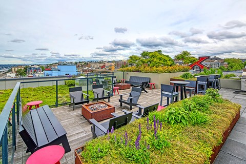 A patio with a table and chairs overlooking a cityscape.