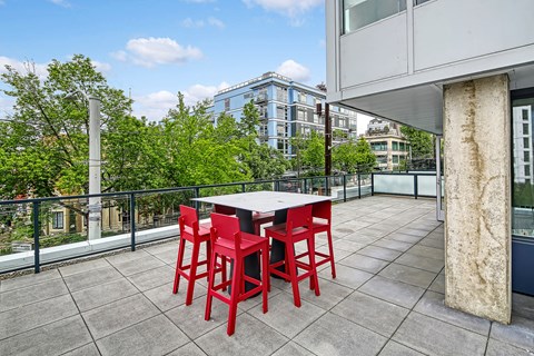 A table with four red chairs is on a patio.