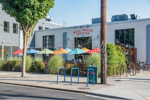 the exterior of pollywood trader on a sidewalk with umbrellas