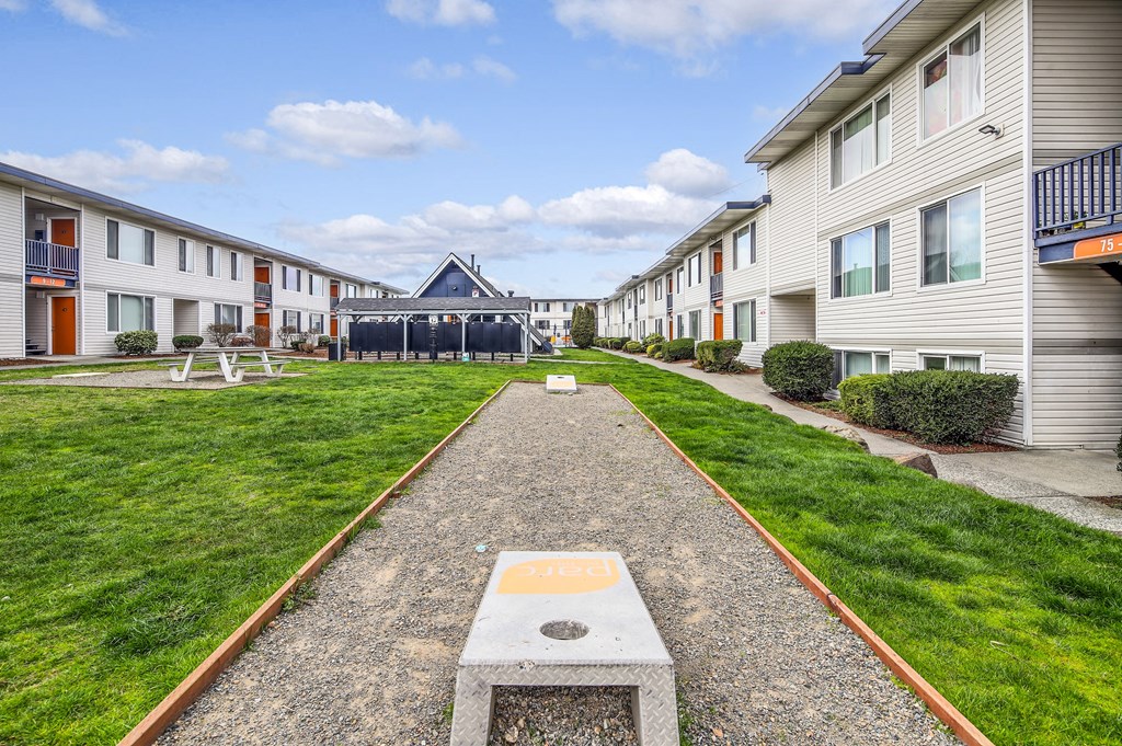 a path leading to a building in the middle of a grassy area