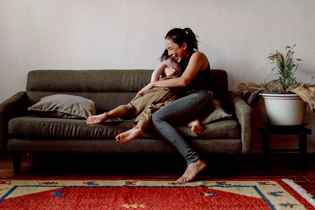a woman sitting on a couch holding a baby