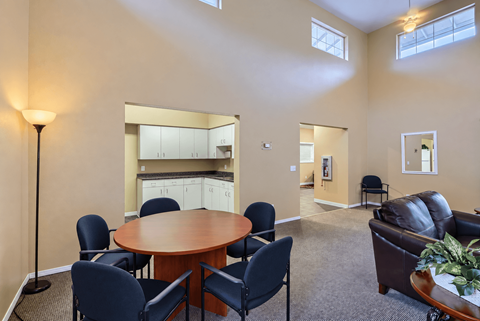 A conference room with a table, chairs, and a couch.