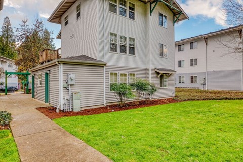 A building with a green door and a small tree in front of it.
