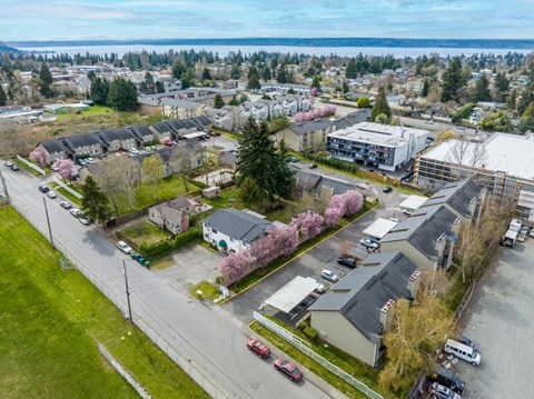A view of a residential area with houses, cars, and a street.