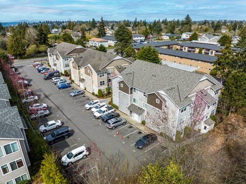 A parking lot with cars and apartment buildings in the background.