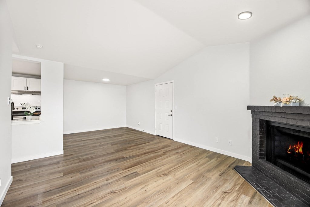 a living room with a fireplace and wooden floors