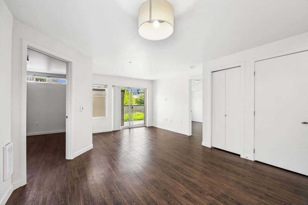 an empty living room with white walls and wood floors