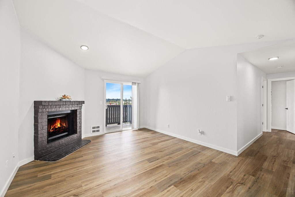 a living room with a fireplace and a door to a balcony