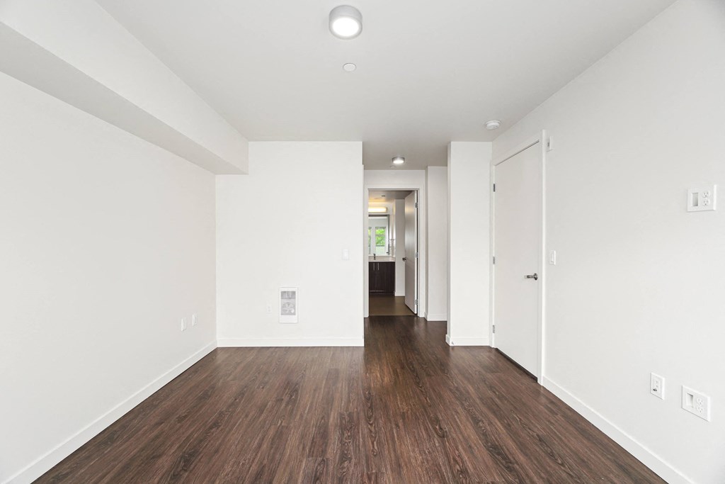 a living room with white walls and wood floors