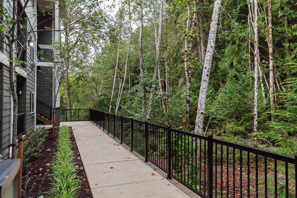 a balcony with a view of a forest and a house
