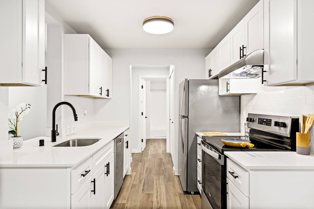 a kitchen with white cabinets and a stainless steel refrigerator