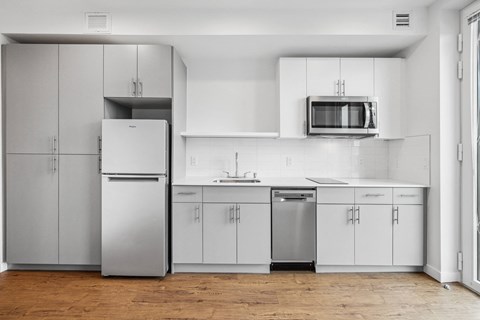 a white kitchen with stainless steel appliances and white cabinets