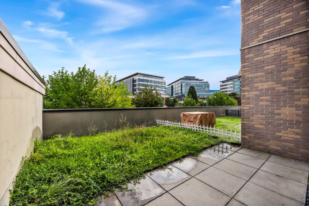 a backyard with a table and a fence and buildings in the background