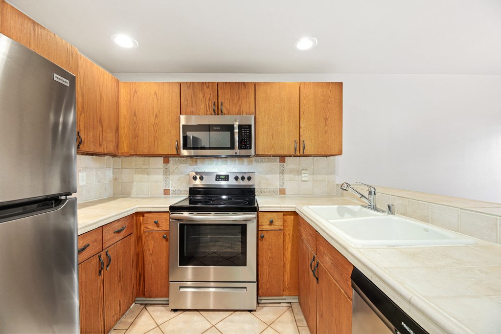 a kitchen with stainless steel appliances and wooden cabinets