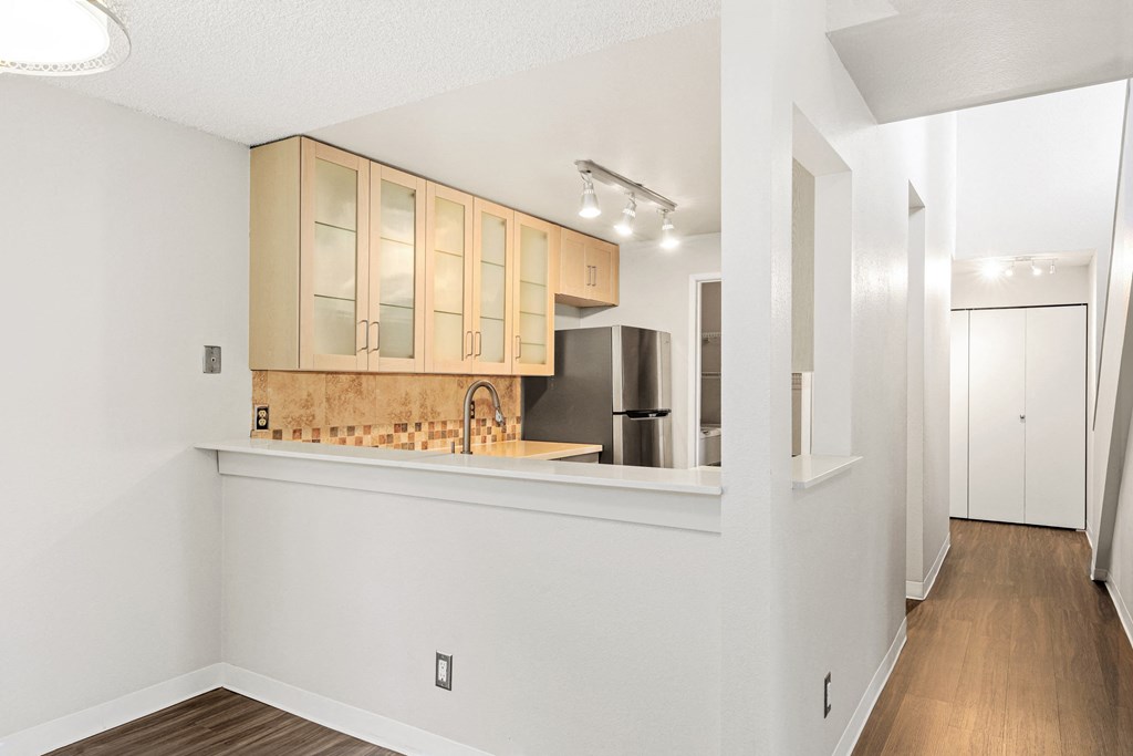 a kitchen with white cabinets and a stainless steel refrigerator