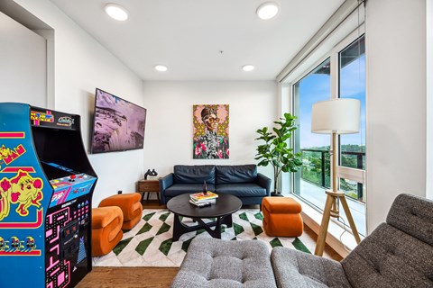 a living room with a couch and a jukebox and a large window