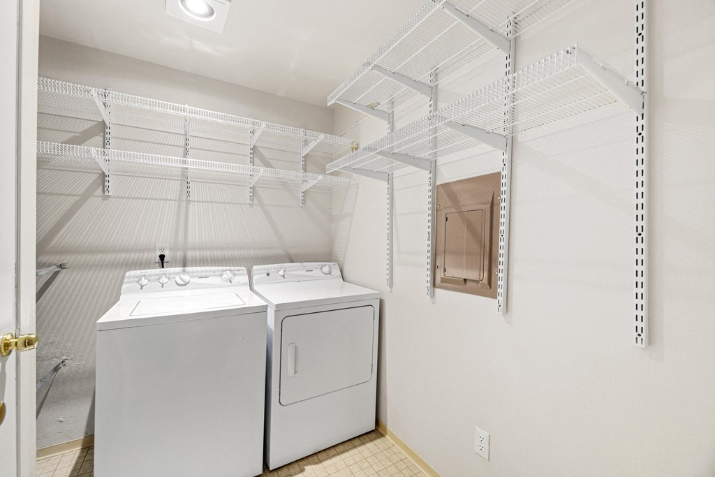 a washer and dryer in a laundry room with white walls and a closet
