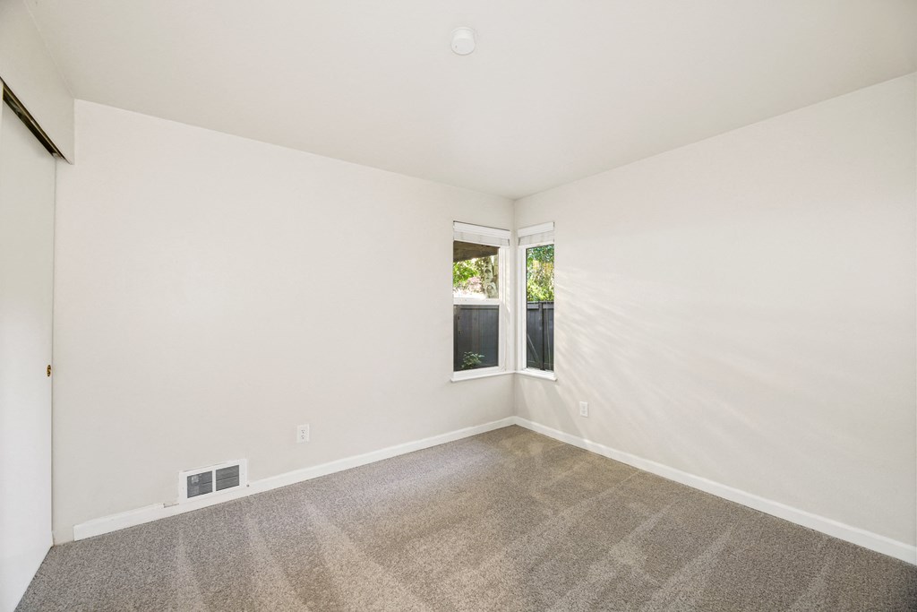an empty room with carpet and a window