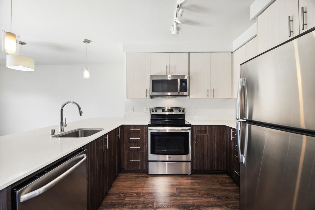 a modern kitchen with stainless steel appliances and white counter tops