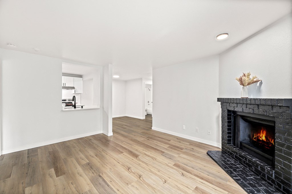 a living room with a fireplace and wooden floors
