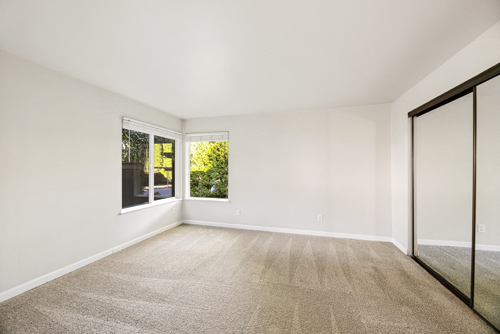 an empty living room with white walls and a window