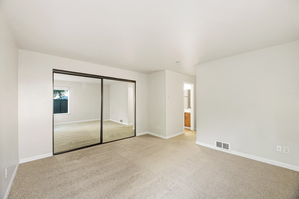 a living room with carpet and a sliding glass door