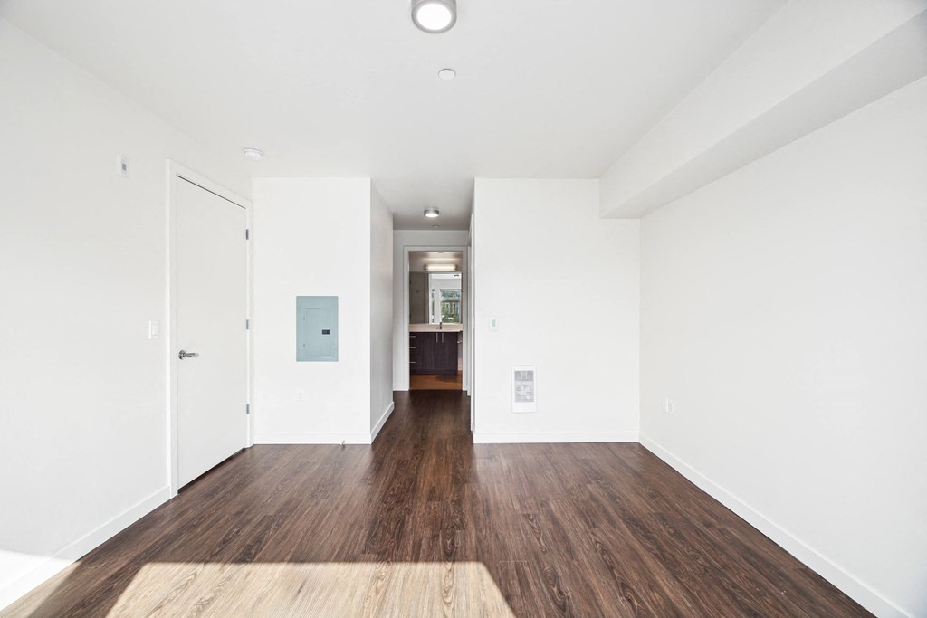 a renovated living room with white walls and wood floors