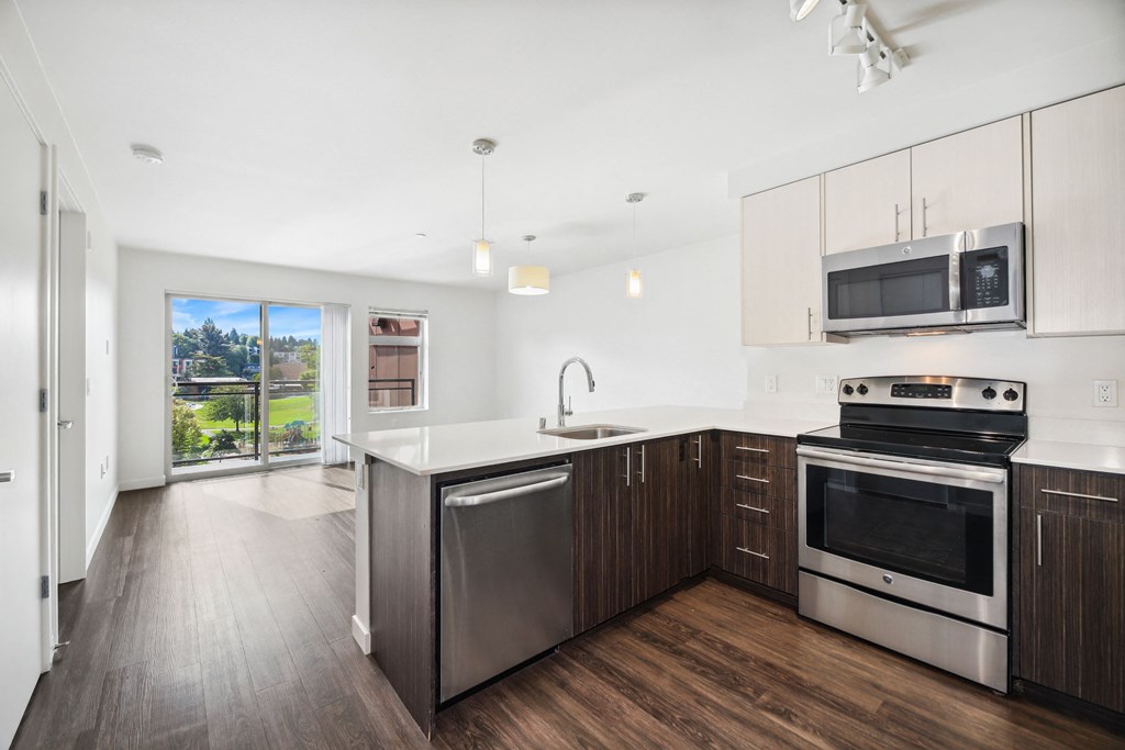 a modern kitchen with stainless steel appliances and white cabinets