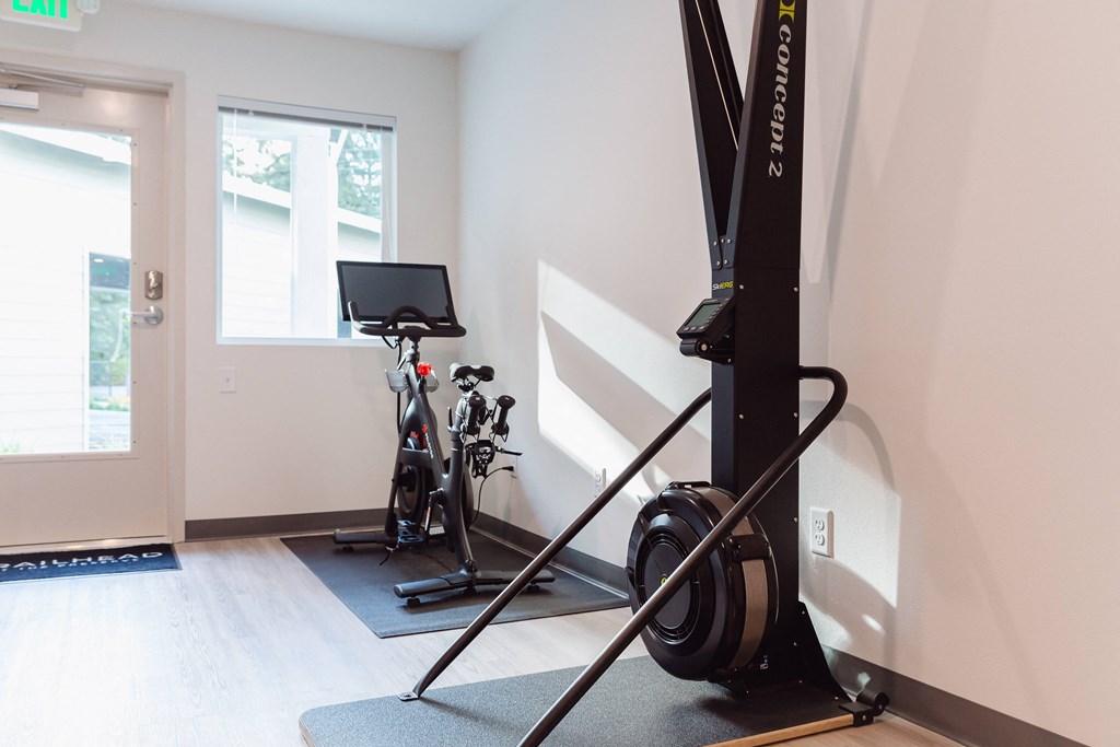 a home gym with exercise equipment in a white room