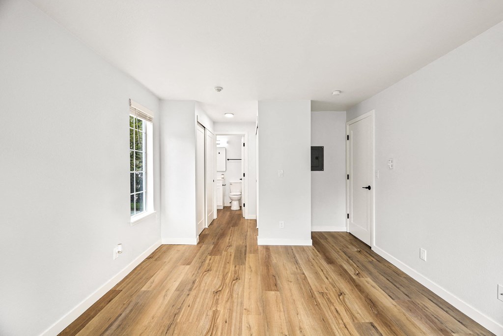 a living room with white walls and a wood floor
