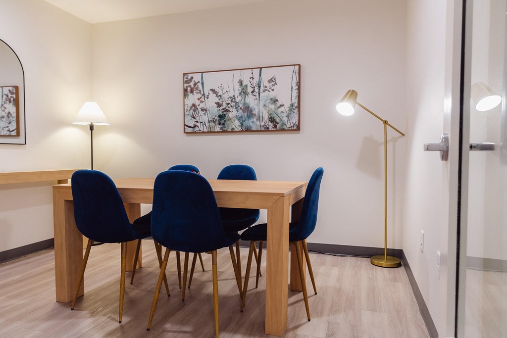 a dining room with a wooden table and blue chairs