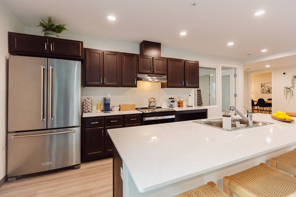 a large white counter top in a kitchen with stainless steel appliances