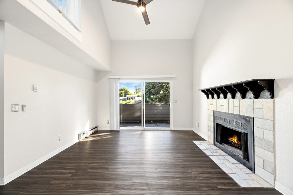 an empty living room with a fireplace and a sliding glass door