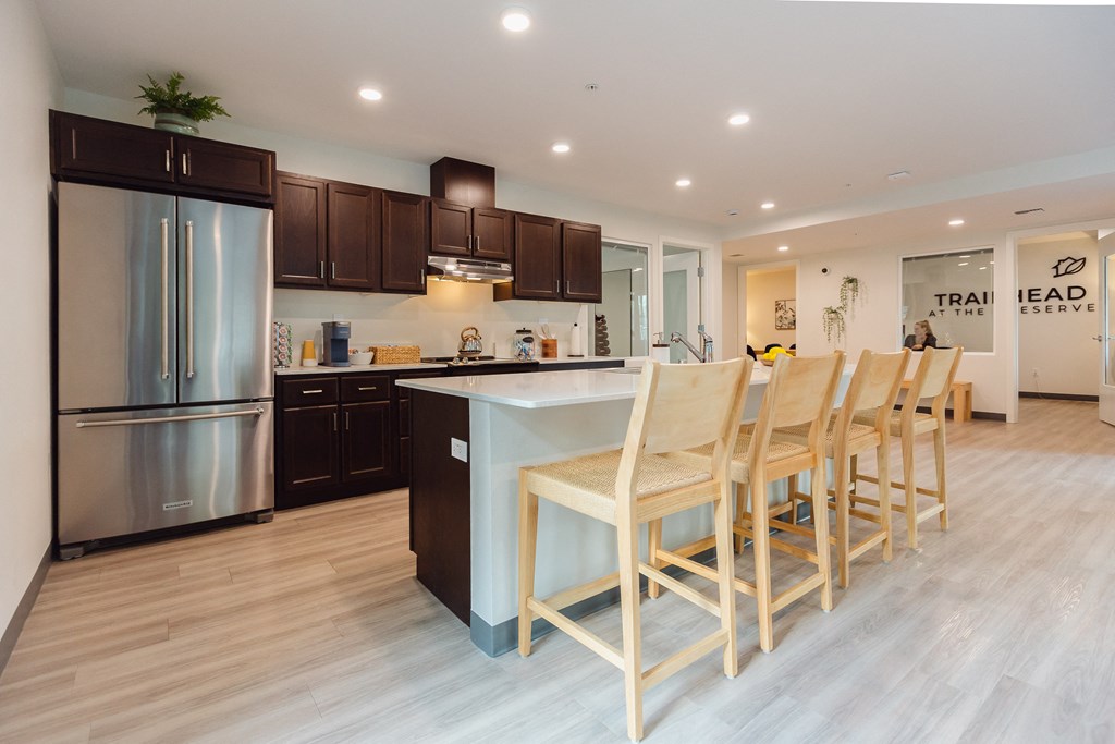 a kitchen with stainless steel appliances and a large island with chairs