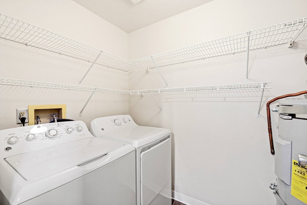 a washer and dryer in a laundry room with white walls and white appliances