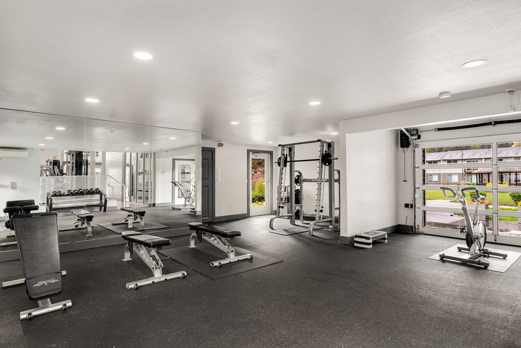 the gym with weights and cardio equipment at the apartments